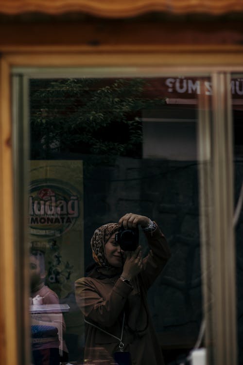 Free Reflection of a Woman in a Window Glass Taking Selfie Stock Photo
