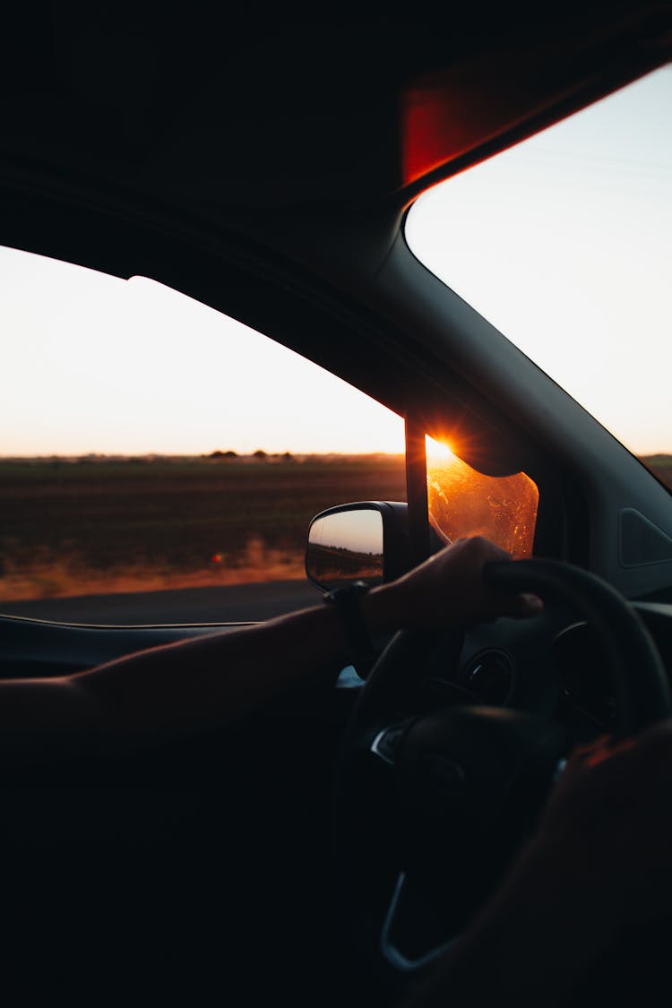 A Person Driving Car During Sunset