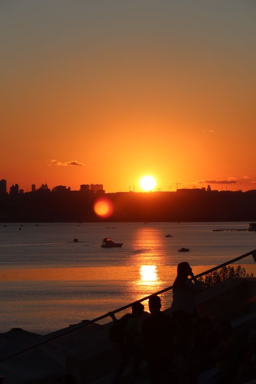 Free Breathtaking view of the İstanbul skyline silhouetted against a vibrant sunset, reflecting on the sea. Stock Photo
