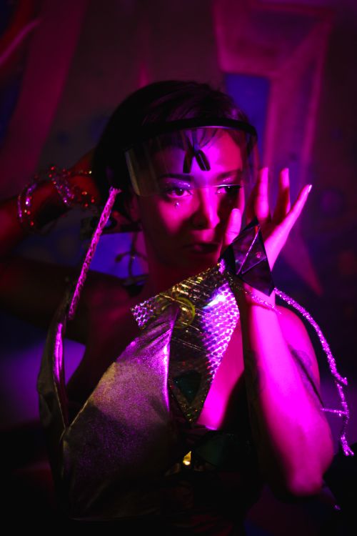 Free Captivating portrait of a woman in metallic outfit with neon lighting, indoors, conceptual and artistic. Stock Photo