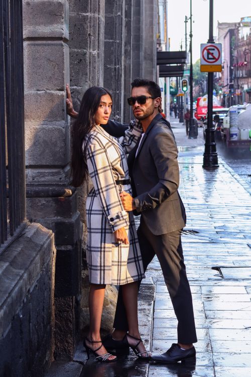 Free Elegant couple standing on a damp street in Mexico City, exuding urban sophistication. Stock Photo