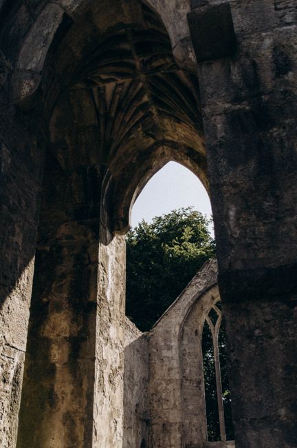 Dramatic low angle shot of a historic Gothic archway highlighting its architectural beauty.