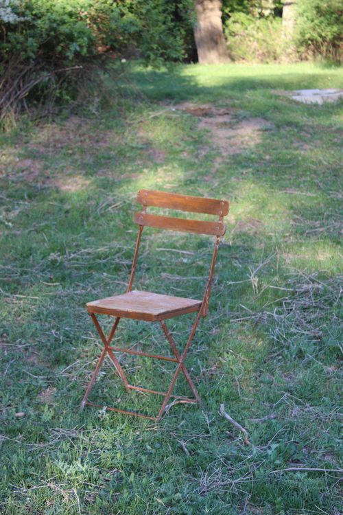 Free A solitary wooden chair on green grass in a serene garden setting. Stock Photo