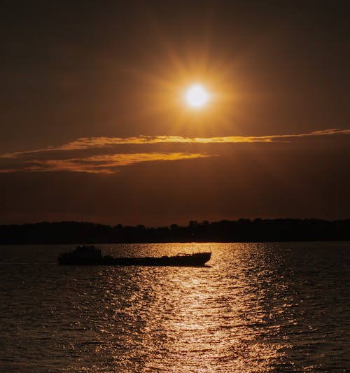 Silhouette of Boat on Sea during Sunset