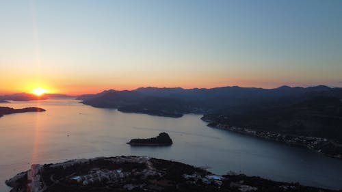 Aerial Photography of Mountains near Ocean during Sunset