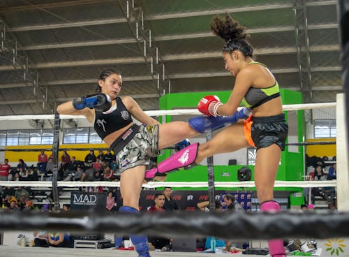 Two Women Kick Boxing in a Boxing Ring