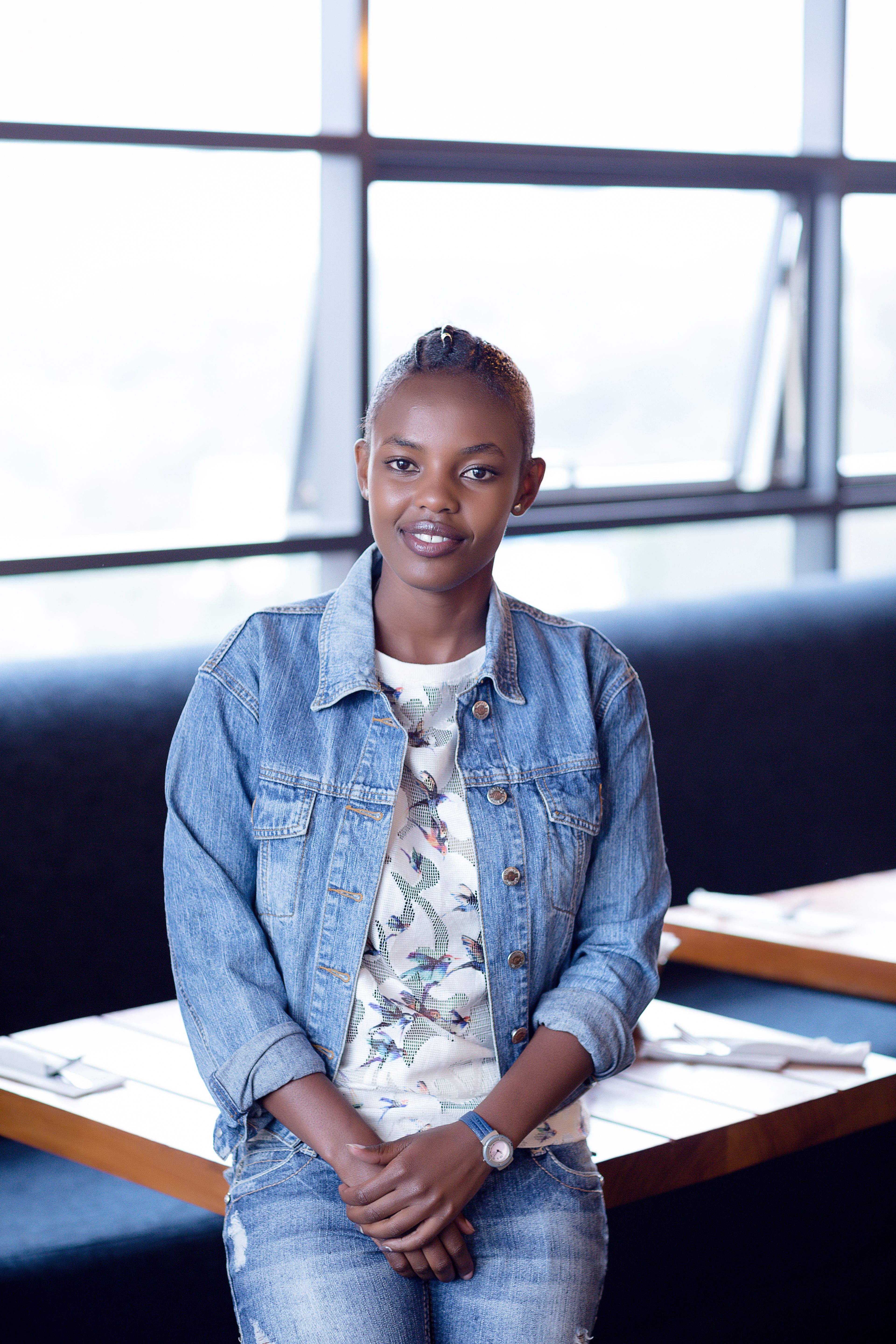 Woman in Denim Jacket Sitting on a White Concrete Fence · Free Stock Photo