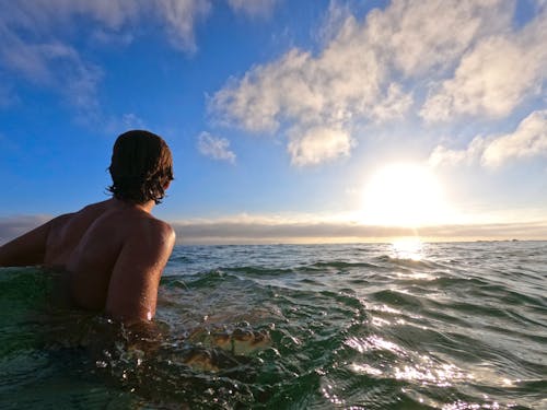 Foto profissional grátis de céu azul, corpo d'água, homem