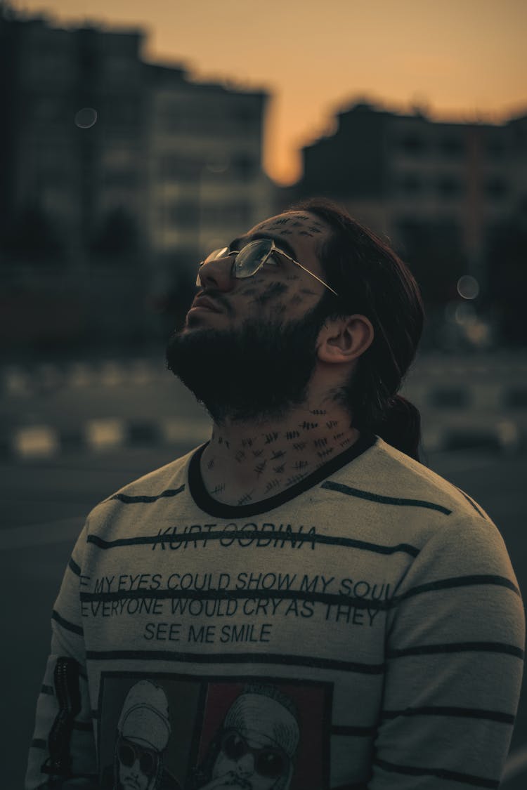 Man With Tattoos On Face Looking Up