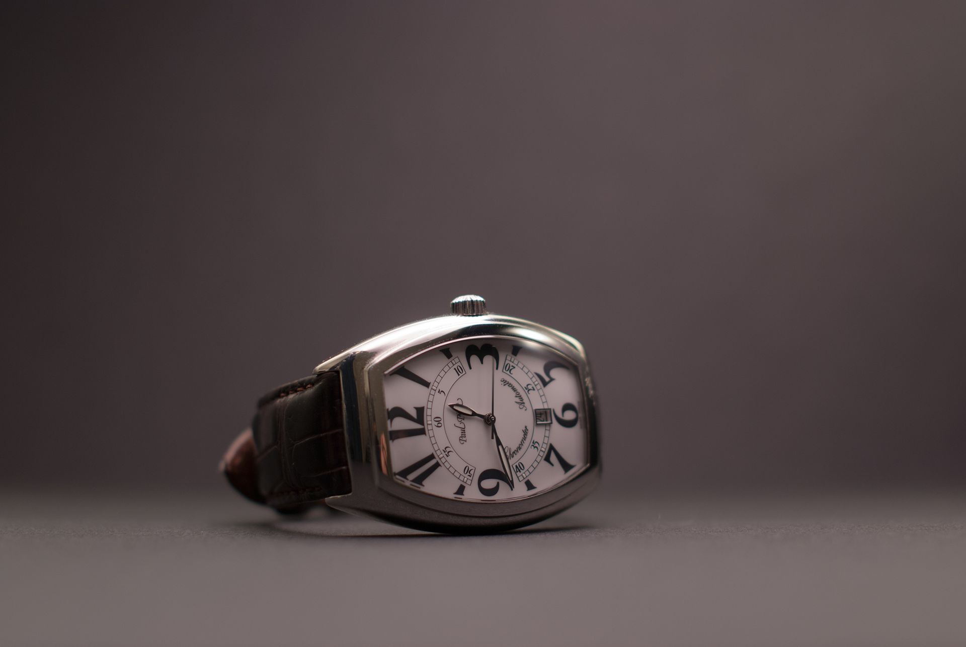 Close-up shot of a vintage luxury wristwatch with a leather strap, highlighting timepiece design.