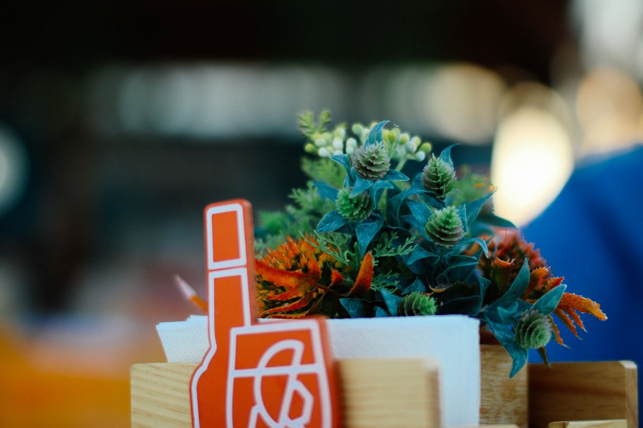 an artistic close up of a floral arrangement with a decorative sign fe