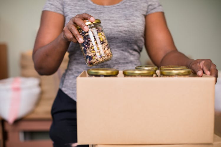 Putting Of Mixed Nuts In Glass Containers On A Box