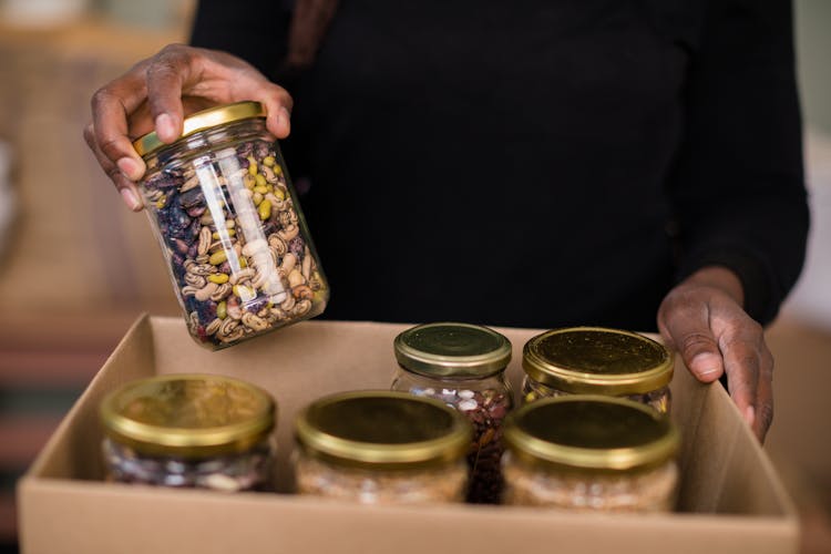 Putting Of Mixed Nuts In Glass Containers On A Box