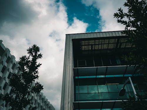 Gray Building with Glass Windows Under White Clouds