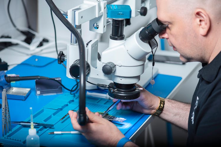 A Technician Using A Microscope