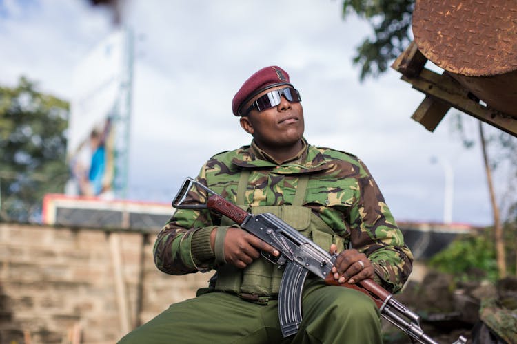 Man In Military Uniform Holding A Rifle