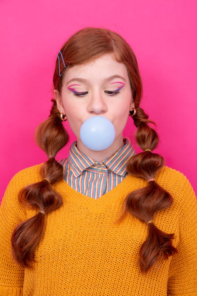 Redhead Girl Blowing A Chewing Gum Balloon