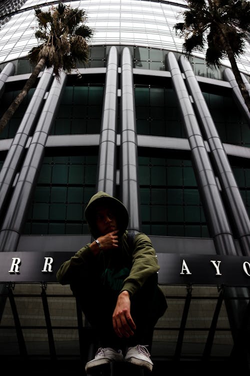 Man Crouching near Building