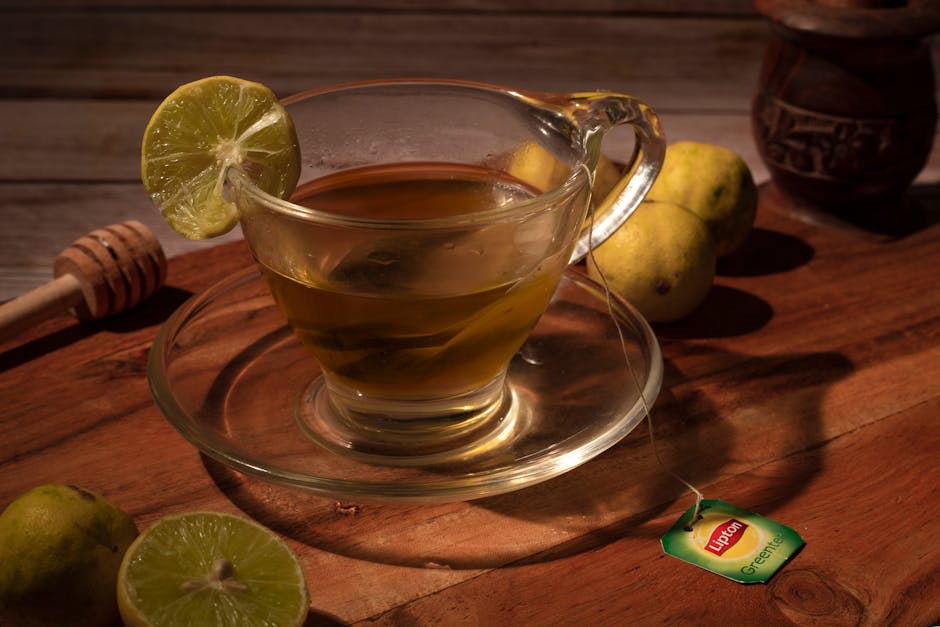 4. Flunssan ja yskän luonnollinen hoito 4. Flunssan ja yskän luonnollinen hoito - Close-up of lemon tea with honey on a wooden surface, evoking warmth and comfort.