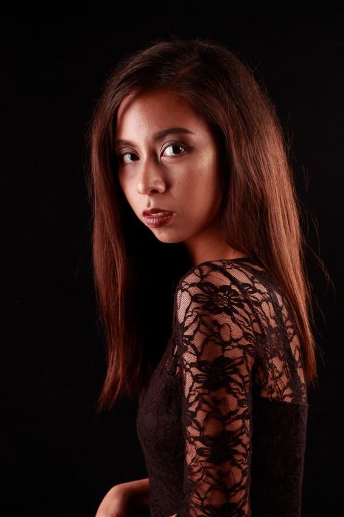 Free Studio portrait of an Asian woman in a black lace dress, showcasing elegance and poise. Stock Photo