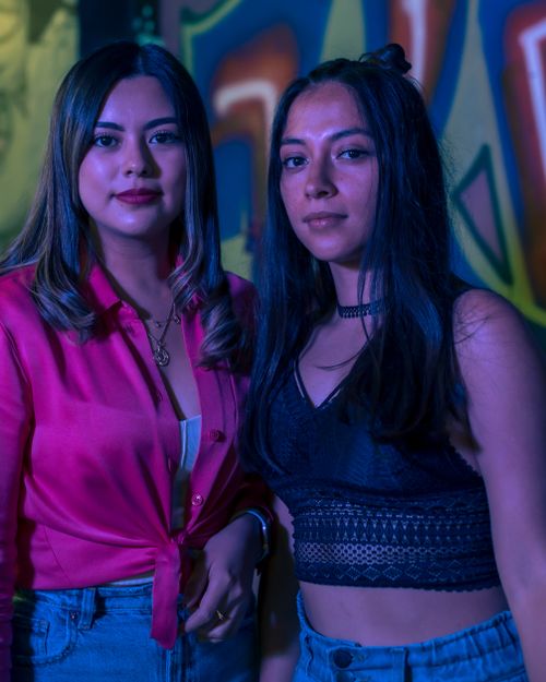 Free Two fashionable women pose in a vibrant indoor setting, showcasing bright attire and modern style. Stock Photo