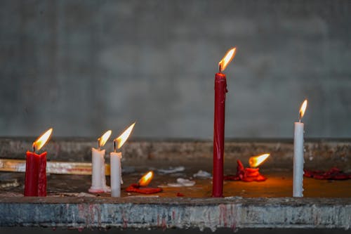 Free Lighted Red and White Candles on Concrete Stock Photo