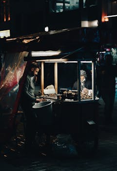 Street food vendor at night with a food cart, vibrant urban atmosphere.