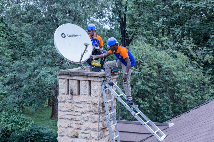 Workers Placing Antenna On Chimney