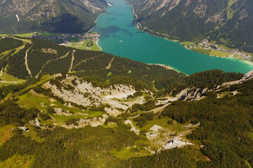 An Aerial Photography of a Lake Between Green Grass Field and Mountain