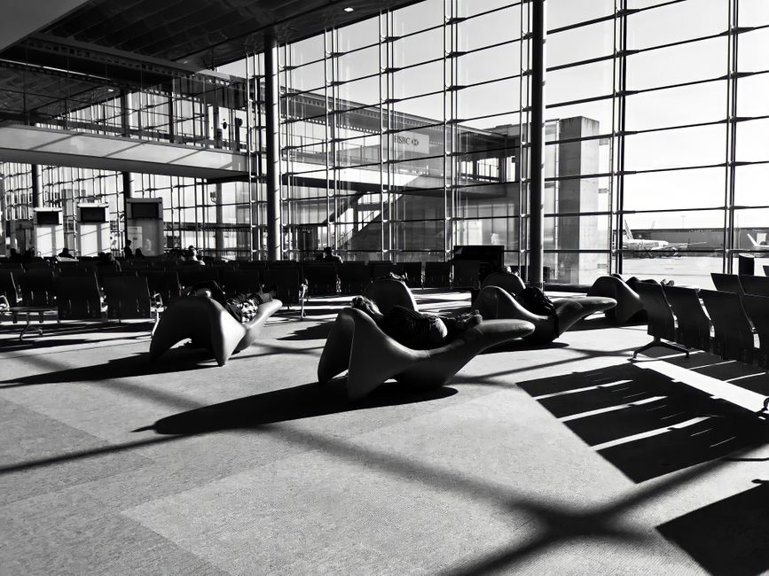 A modern airport lounge in Roissy-en-France, France, captured in monochrome with unique seating arrangements.