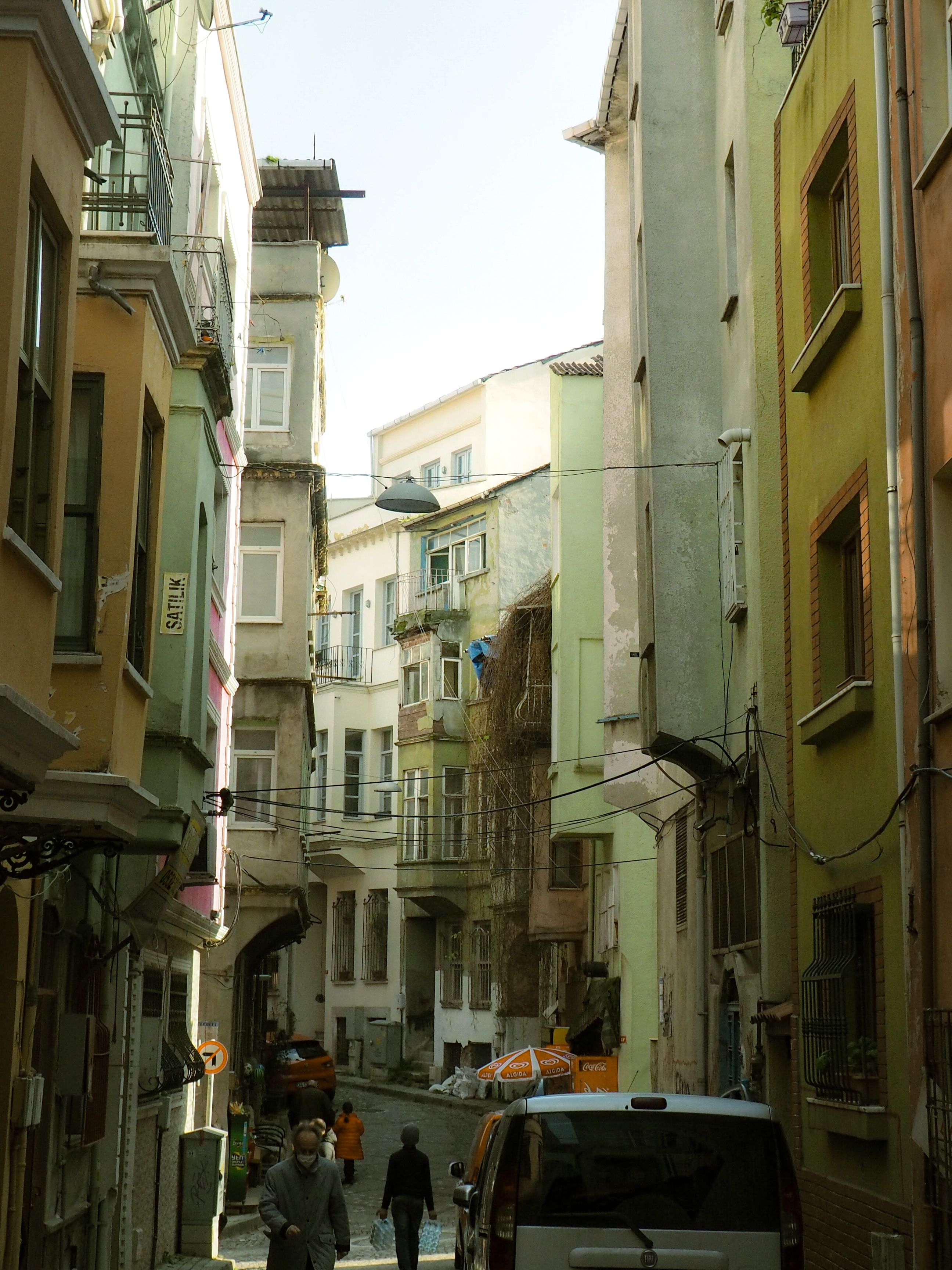 People Walking on a Narrow Street Between Buildings · Free Stock Photo