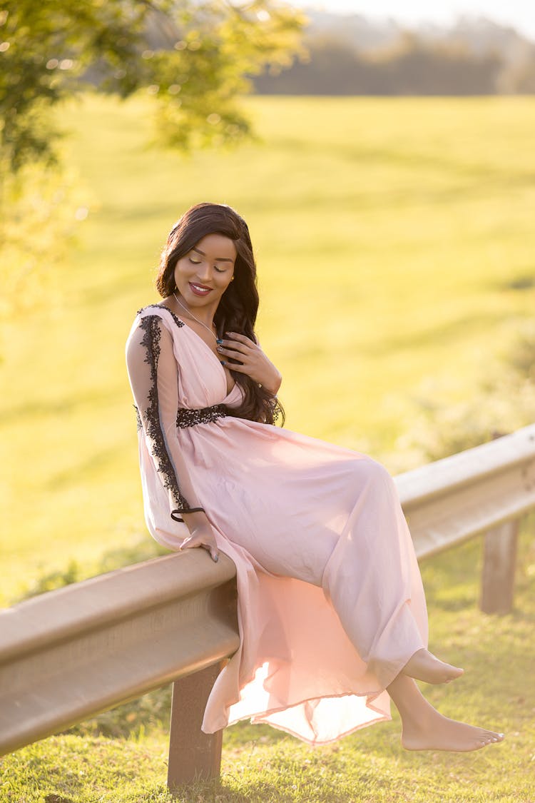 Woman In White Dress Sitting On Barrier 