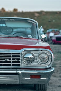 Front view of vintage Chevrolet car showcasing its chrome grill and headlights in an outdoor setting.