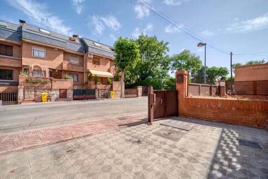 Picturesque suburban brick homes with sunny street view, showcasing serene urban lifestyle.