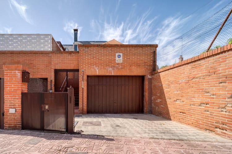 Brown Brick House And Concrete Driveway Under Blue Sky