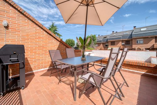 Free Modern terrace with table, chairs, and umbrella under the sun. Ideal summer setting. Stock Photo