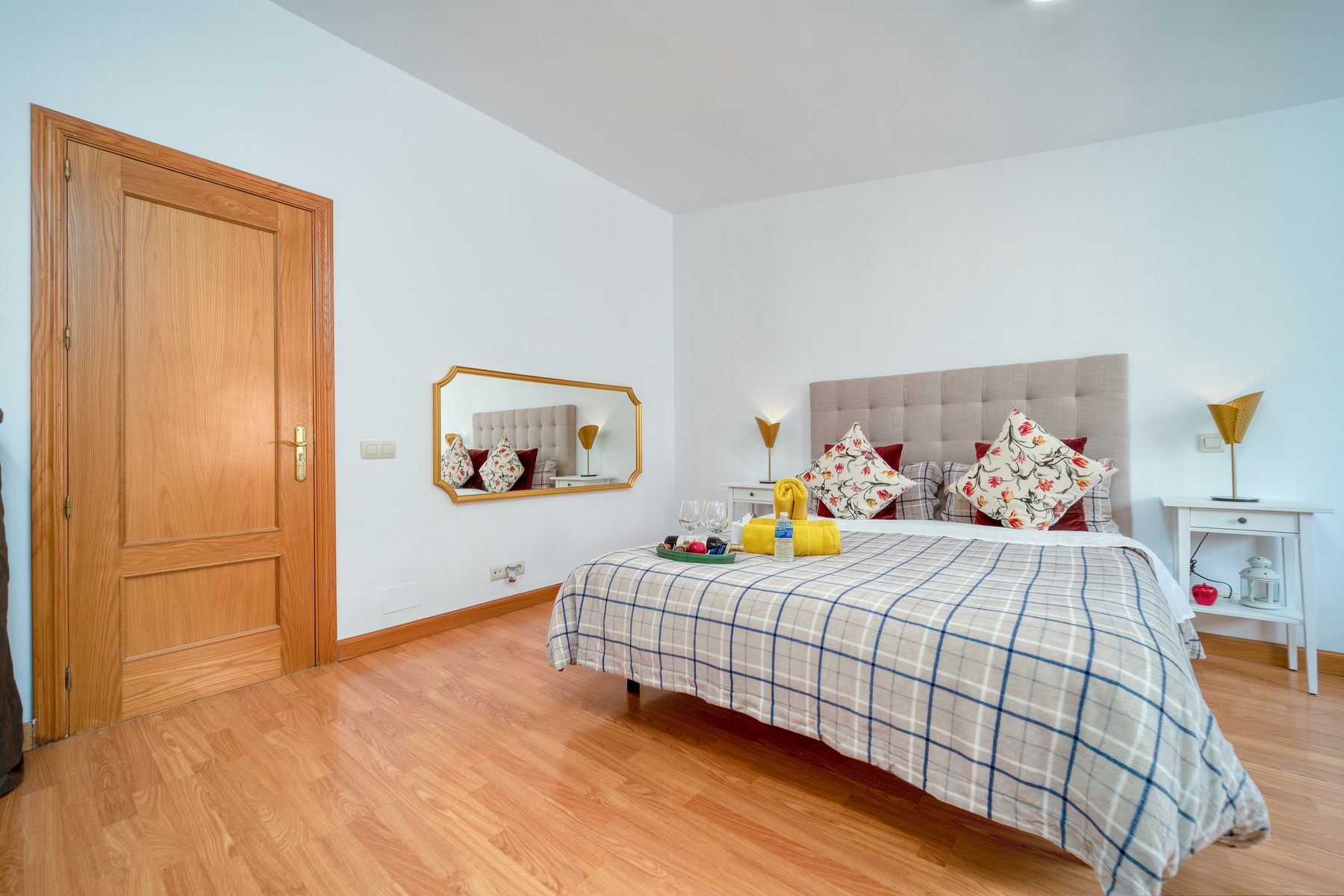 Bedroom with patterned textiles combining ochre, cream and darker grounding colors