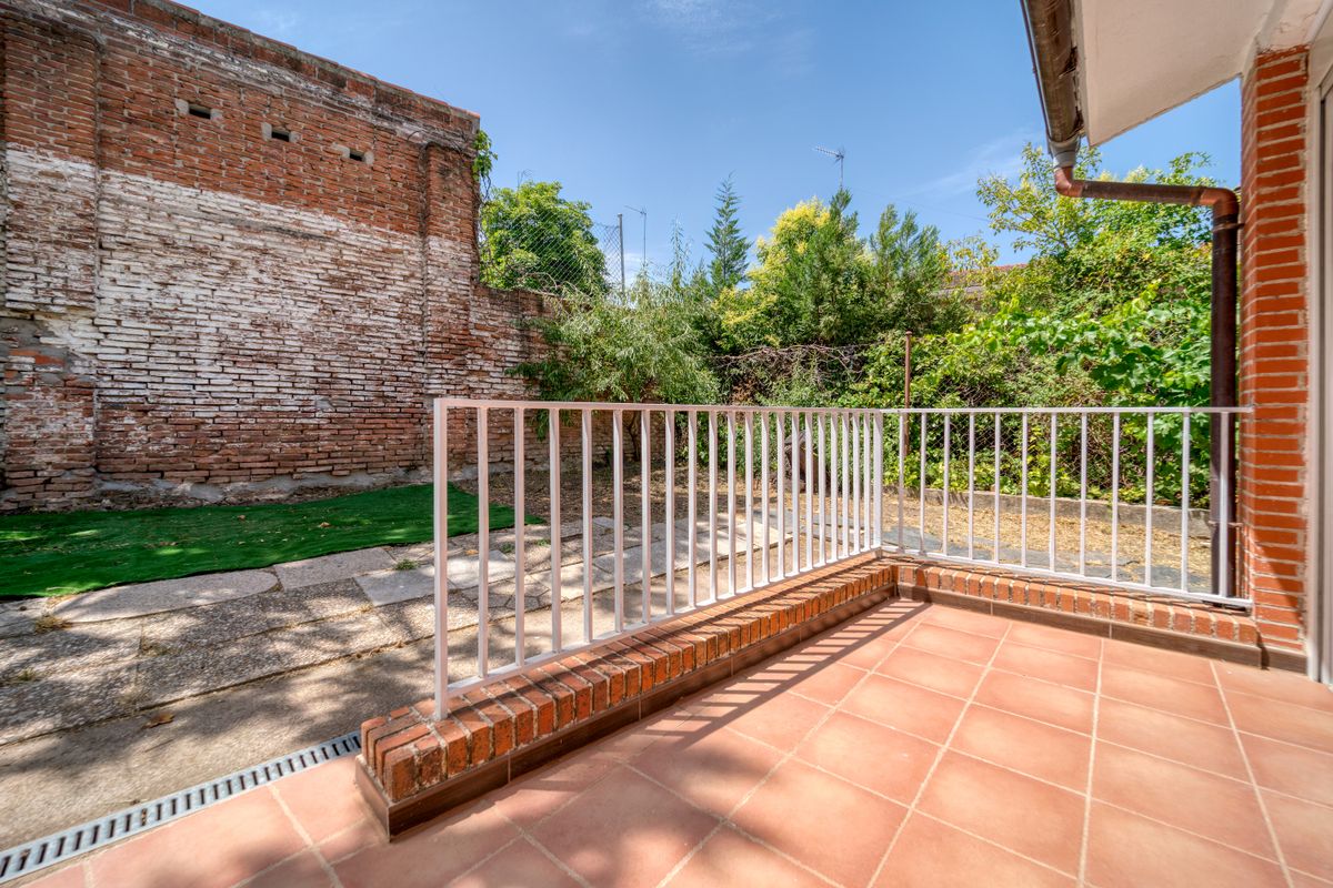 Terasă exterioară spațioasă, cu pereți de cărămidă aparentă și balustrade metalice pe margine