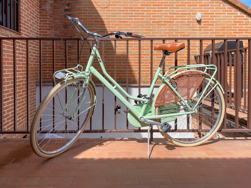 Green Bicycle Parked Beside Metal Railing