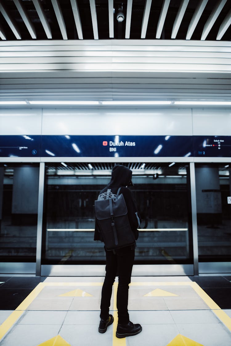 Back Of A Man Standing At A Subway Station