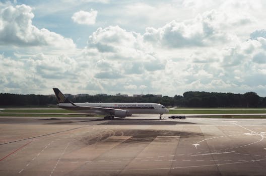 A Singapore Airlines plane on a runway under a cloudy sky, ready for takeoff.