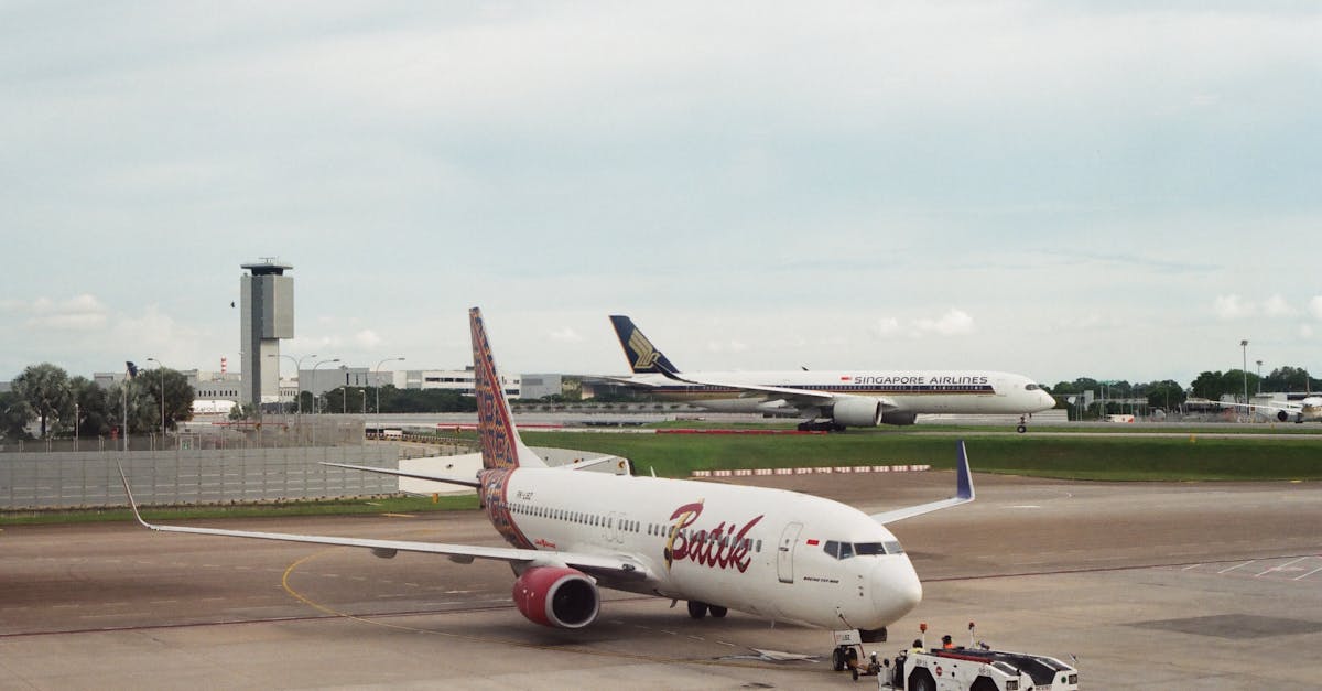 Photo by Vinh Lâm Two airplanes at an airport, showcasing commercial aviation on the tarmac.