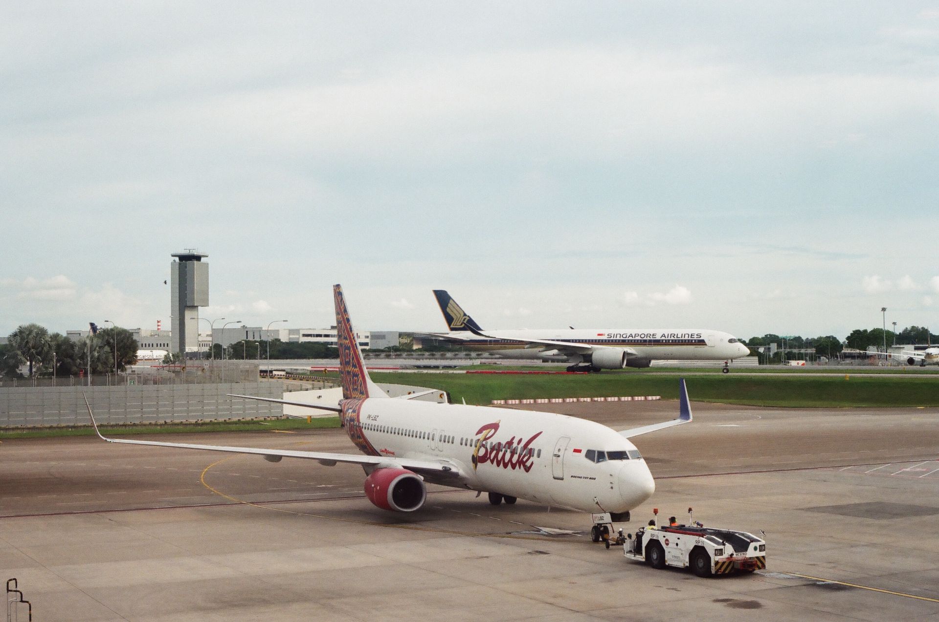 Two airplanes at an airport, showcasing commercial aviation on the tarmac.