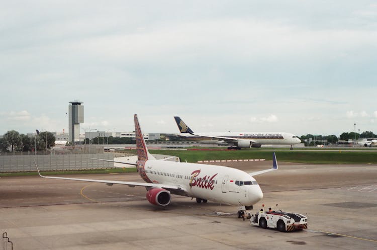 An Airplane With Tug On The Runway