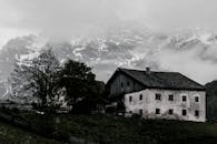 山上废弃的农舍笼罩在雾中，营造出神秘的冬季景观