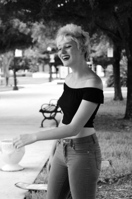 Black and white portrait of a joyful young woman in a Los Angeles park.