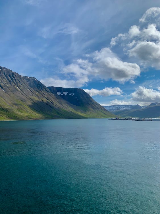 A Mountain Near the Body of Water Under the Cloudy Sky