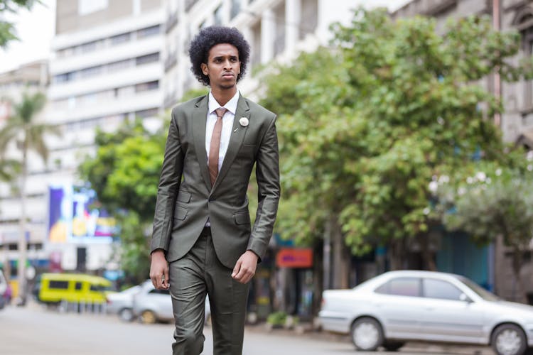 A Man With Curly Hair Wearing A Suit