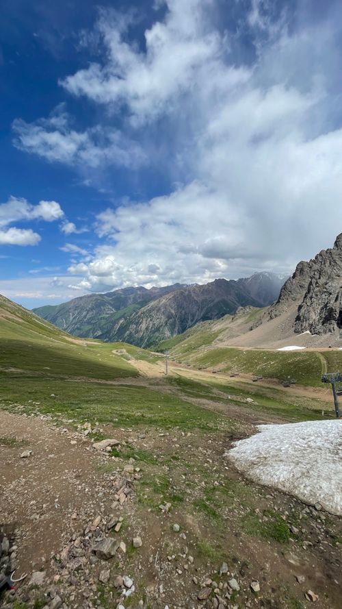 Free Breathtaking mountain valley under blue sky with lush greenery and rocky peaks. Stock Photo