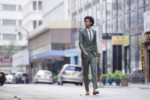 Free A Man in a Suit Walking on the Road  Stock Photo
